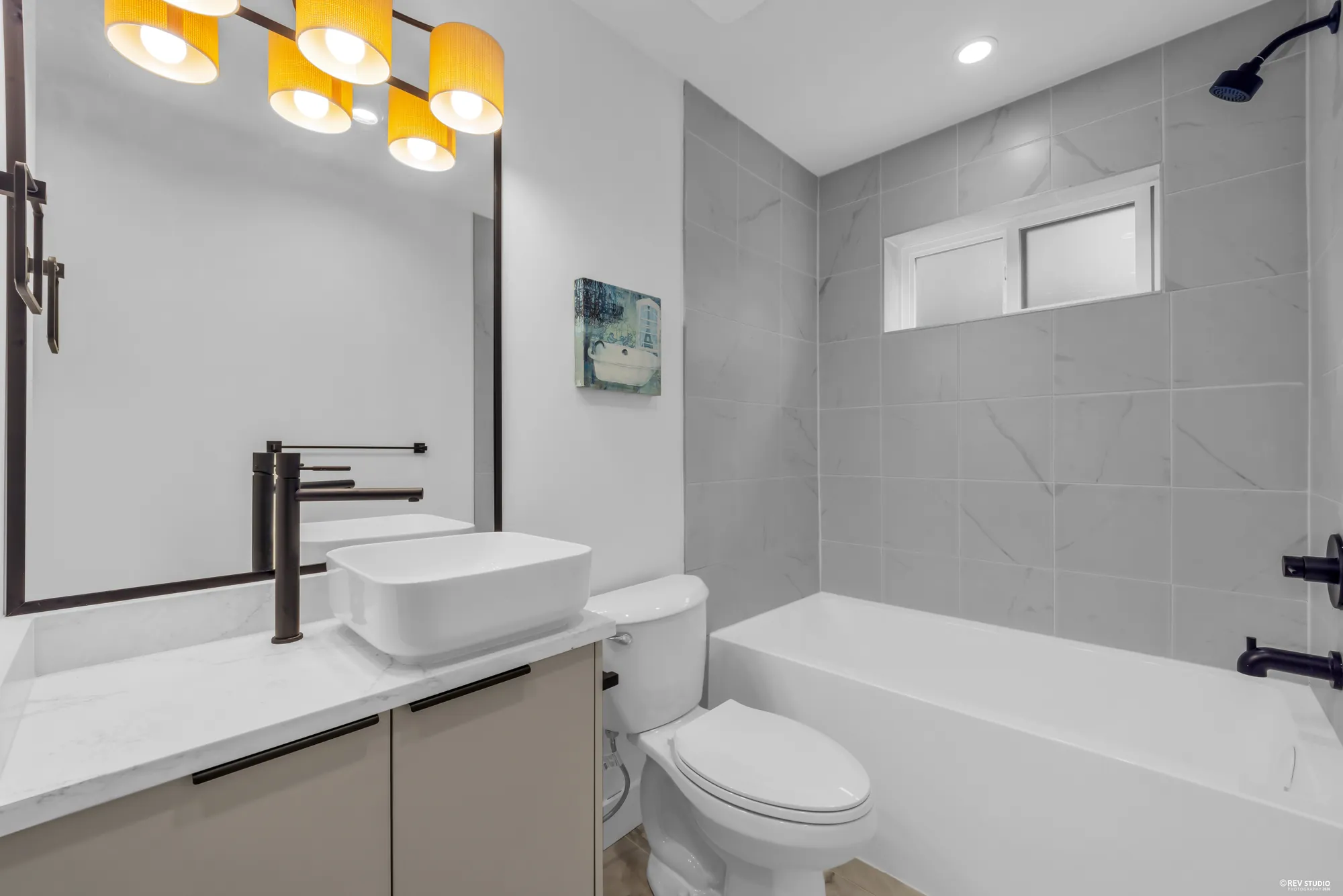 Bathroom with a tub and shower, vessel basin and pendant lights