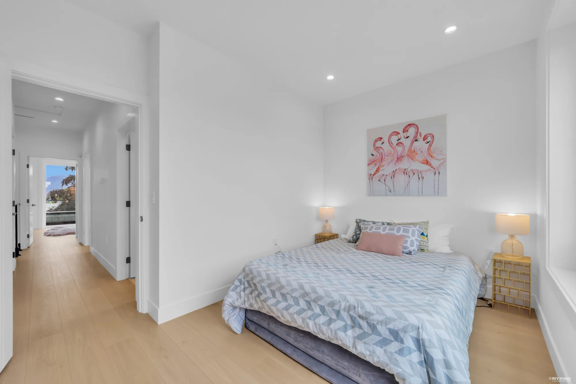 Second bedroom with a double bed, two bedside tables and framed art
