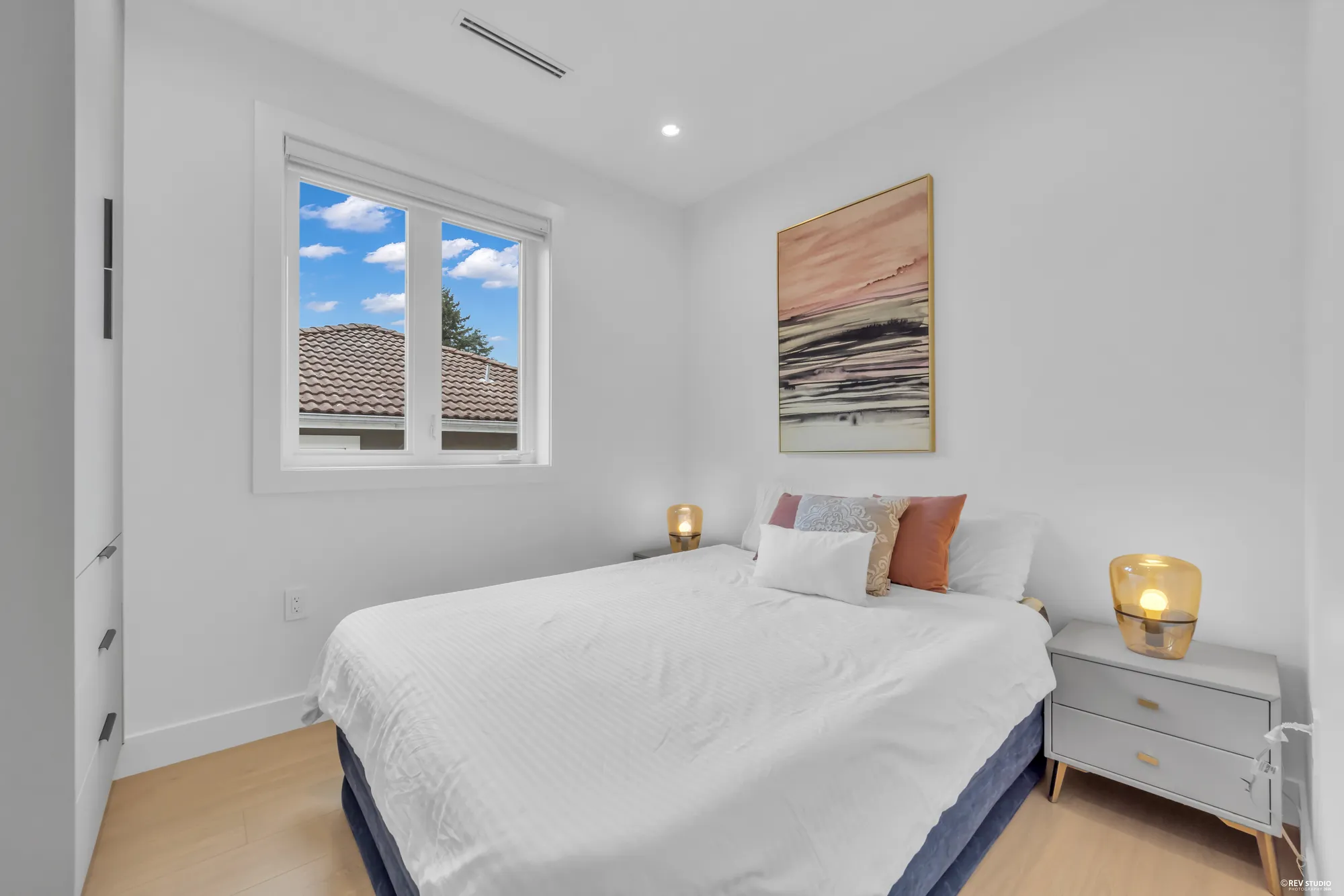 Third upper bedroom with a bed under a window and a bedside table