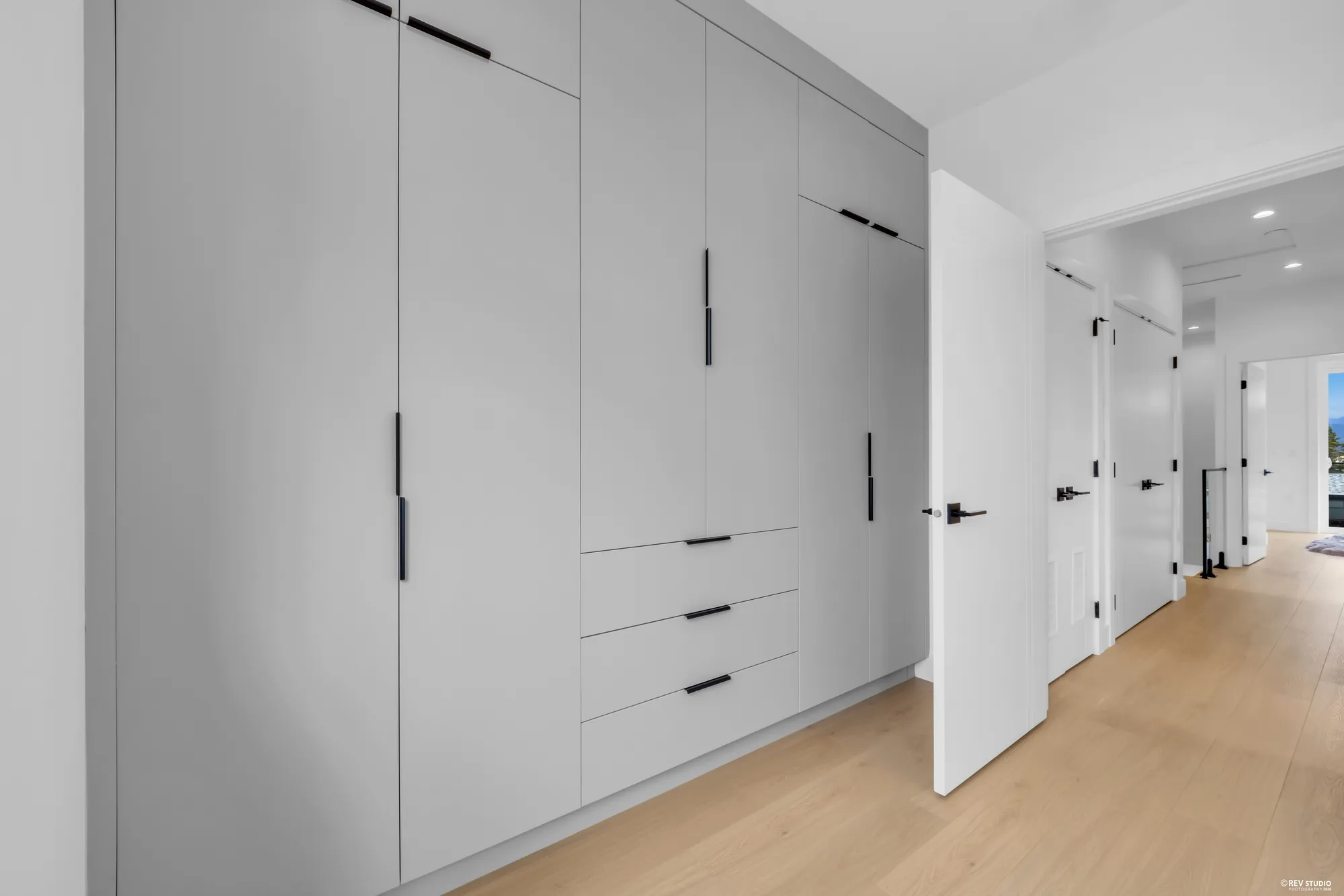 A run of tall built-in wardrobes along a hallway