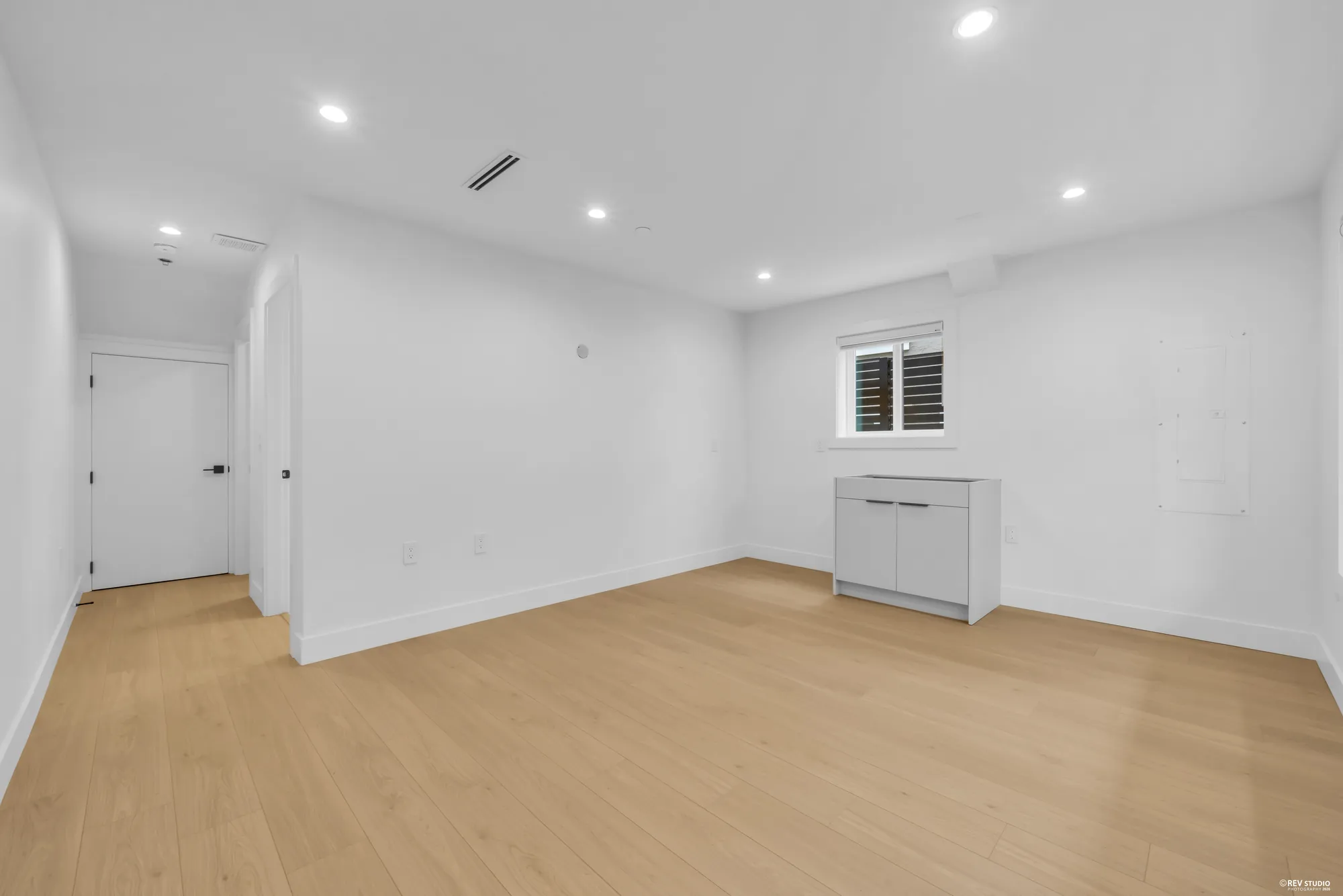 The same unfurnished room from another corner, showing the patio door