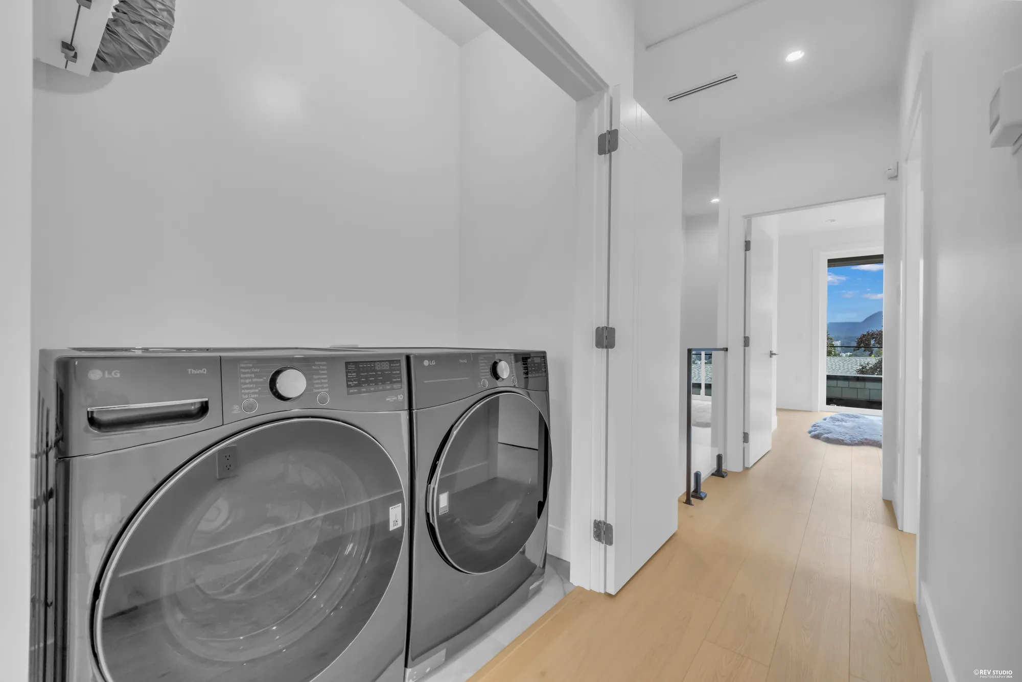 Full-size washer and dryer side by side in a hallway alcove