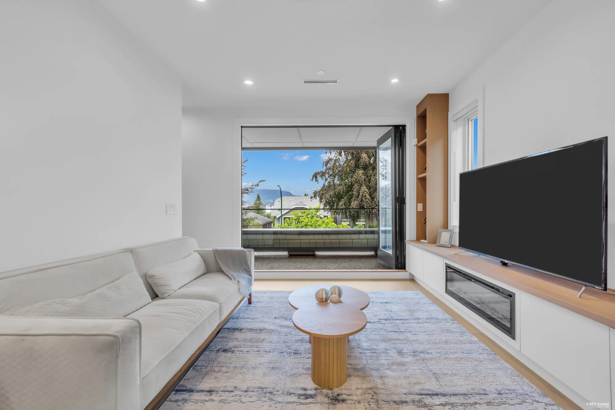 The living room from the other side, showing the fireplace and media cabinetry