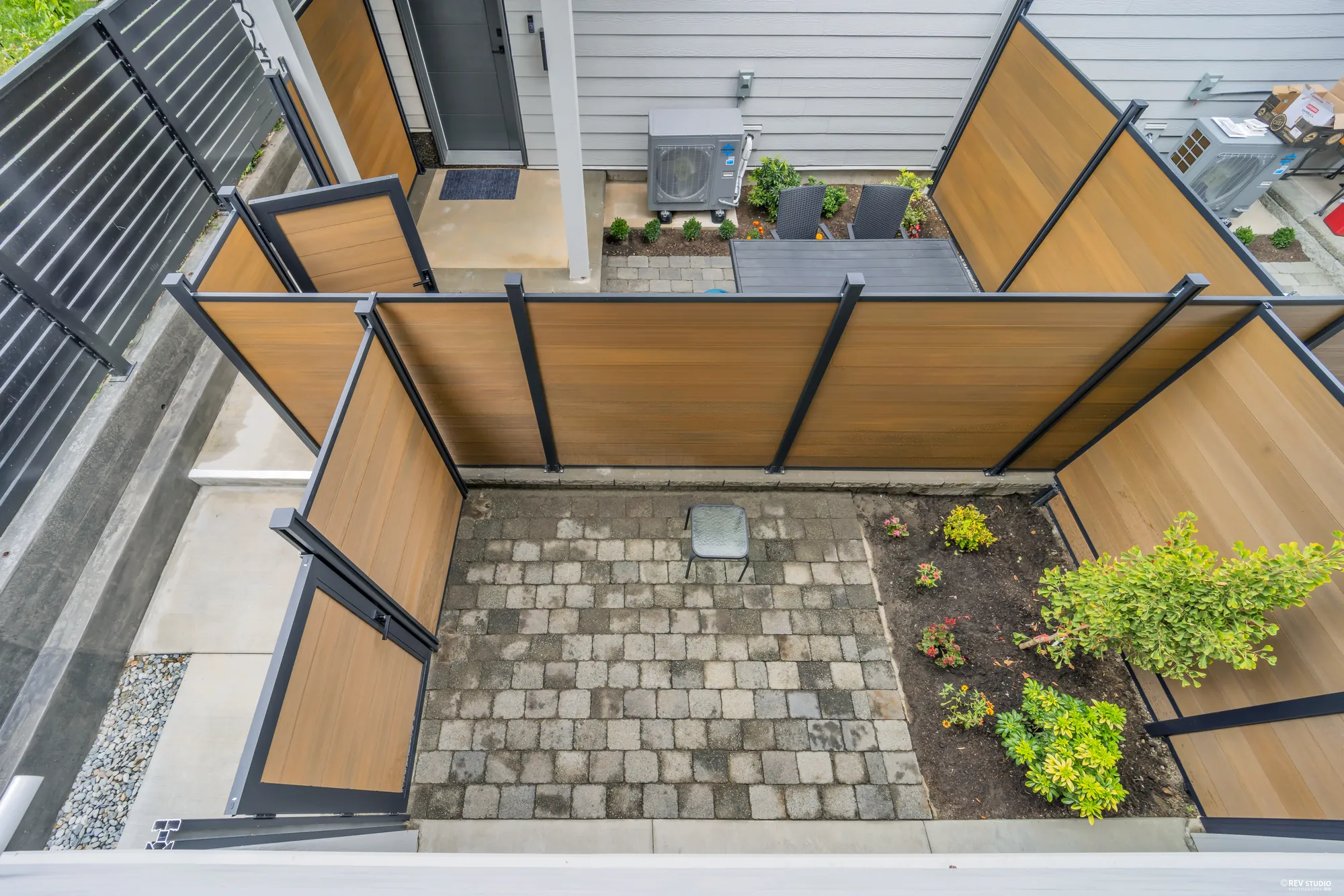 Looking down onto the paved patio and its planting from the balcony above