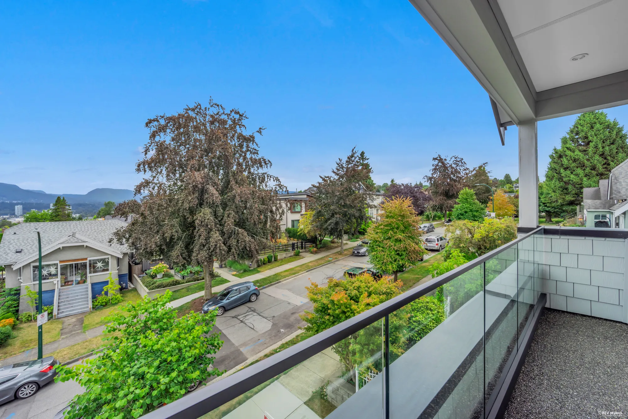 Looking down from a balcony onto Triumph Street, parked cars and front gardens